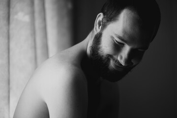 Creativity, man and smile in a bedroom at home with monochrome and black and white. Shy male person, calm thinking and art in the morning in a house with happy memory and relax with solitude - obrazy, fototapety, plakaty