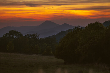 Romantic sunset view in mountains of central Bohemia. Sky is full of colors sun paint hypnotic scenery.