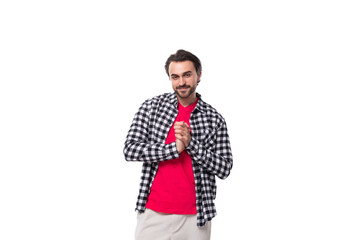 Fototapeta premium young handsome brunette man with a cool hairstyle and beard in a shirt on a white background with copy space