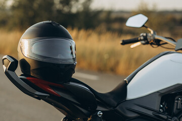 Helmet hanging on the motorbike on the road