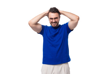 young smart caucasian man with dark well-groomed hair and a beard in a blue t-shirt is brainstorming