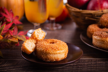 Naklejka na ściany i meble Sweet homemade apple cider donuts with cinnamon sugar on the wooden table. Autumn food.