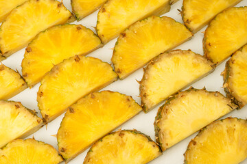 Pineapple juicy yellow slices on a white background.