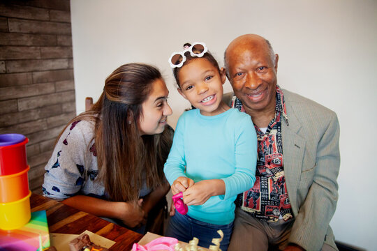 Biracial mother and daughter with black grandpa celebrating birthday wearing sunglasses