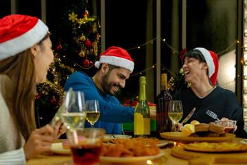 Party of beautiful asian friend female and male celebrating. freind serving pizza on table with snack and drink. happiness friends christmas eve celebration dinner party food and champagne.