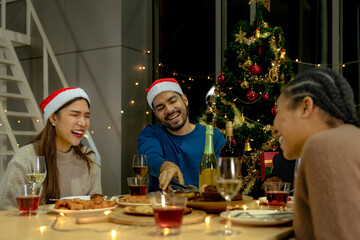 Party of beautiful asian friend female and male celebrating. freind serving pizza on table with snack and drink. happiness friends christmas eve celebration dinner party food and champagne.