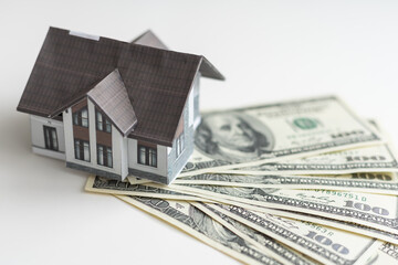 Concept of expenses for new home; small house, dollar paper money.