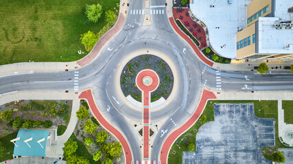 Colorful roundabout road with four exits and hotel in straight down aerial from above statue, Muncie