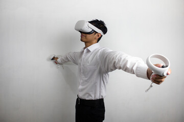 A man wearing a white shirt and black trousers who uses VR (Virtual Reality) technology happily. concept of using virtual reality technology.