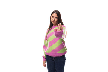 portrait of a well-groomed 35 year old feminine model woman dressed in a pink stylish pullover pointing her hand forward at the camera