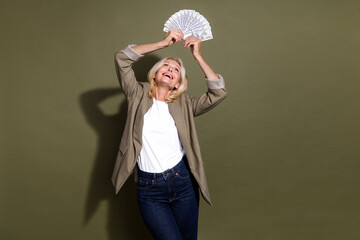 Photo of profitable business concept experienced old successful woman raised income dollars above...