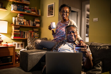 Senior couple online shopping with credit card from laptop at home