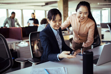 Businesswomen pointing to wireless speaker in the office