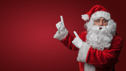 Fototapeta na wymiar Surprised Santa Claus gesturing with both hands, expressing holiday excitement