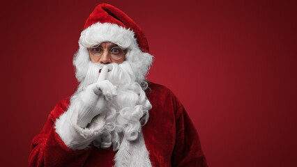Santa Claus gesturing silence with finger on lips, mysterious holiday secret concept