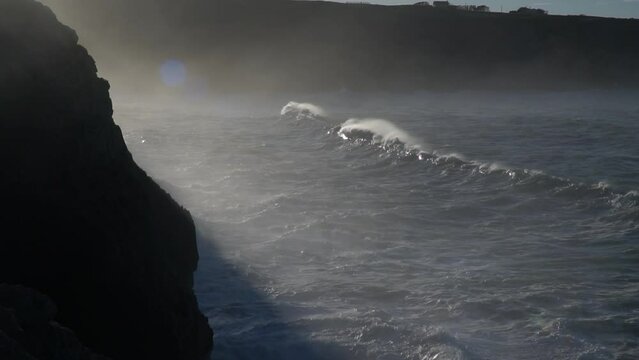 Huge waves hitting the cliff and exploding