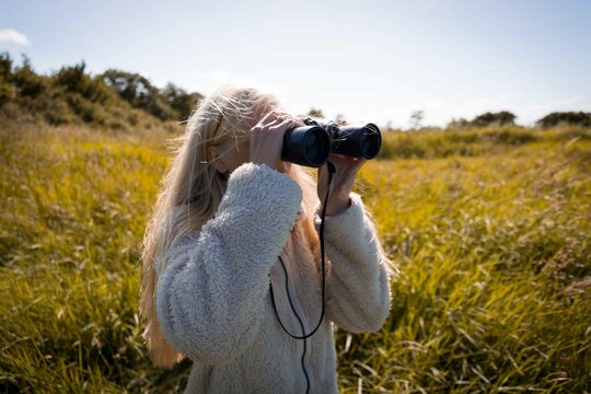 une fille qui observe les oiseaux avec des jumelles