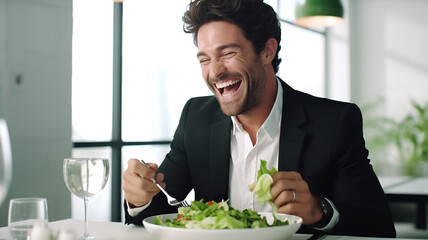 A charming, happy man eating a salad in a restaurant, isolated on a white background - obrazy, fototapety, plakaty