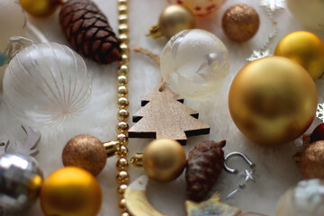 Various colorful Christmas oranments and white faux fur blanket. Selective focus.
