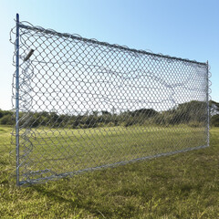 cyclone wire fence, 2.4 meters length, installed on a field cover on grass and some trees on the background.