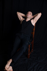 Portrait of a 40-year-old man in black clothes on a dark background