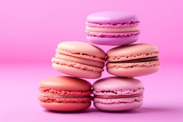 Fototapeta na wymiar a stack of macaroons sitting on top of each other in front of a pink background with one macaroon on top of the other macaroons.