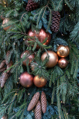 Christmas fir branches with ball ornaments, baubles of gold color on green needles. Xmas decor background