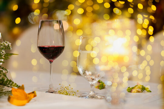 A glass of red wine on table with blur light in restaurant.