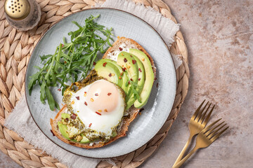 Avocado egg sandwich. Healthy light breakfast concept. Whole grain toasts with avocado and fried pesto eggs