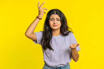 Sad young Indian woman feeling hopelessness loneliness nervous breakdown loses surprised by lottery results bad fortune loss unlucky news game fail. Attractive Hindu girl isolated on yellow background