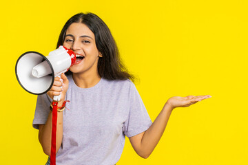 Indian young woman talking with megaphone, proclaiming news, loudly announcing advertisement...