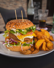 Crispy veggie burger, served with deluxe fries, egg, lettuce, cheese, tomato and onion. With a...