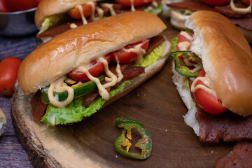 Vegan sandwiches consisting of sliced seitan, peppers, tomato and lettuce. Seasined with mustard