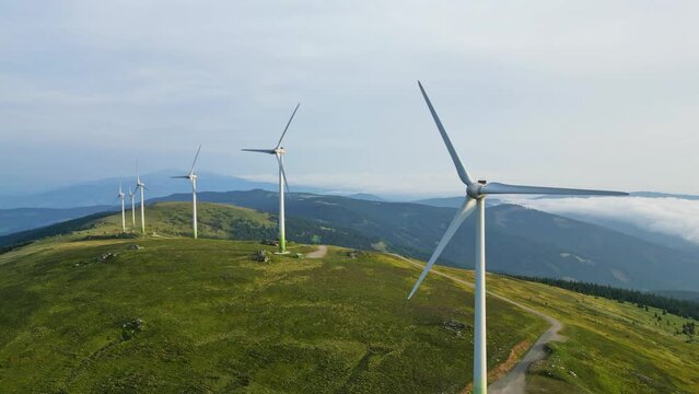 Dynamic flight around a group of wind mills on an idyllic mountain ridge in Austria