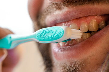 Personal hygiene. Man brushing his teeth with a toothbrush