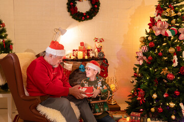 kid boy grandchild open gift box surprise from grandfather while celebrating christmas party in...
