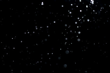 small drops of rain, snow on a black background. wind. Natural background