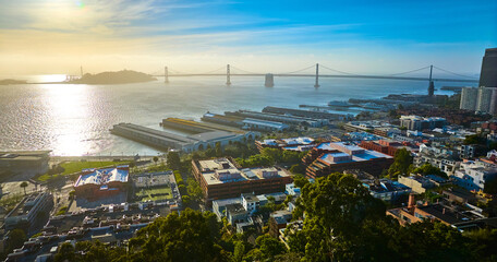 San Francisco coast with golden sunset aerial of city overlooking piers and Oakland Bay Bridge