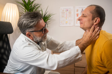 Experienced male bearded doctor check throat for unhappy patient carefully. 