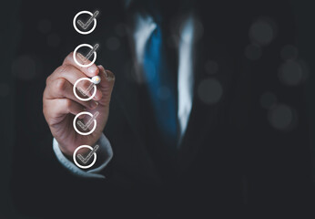 Businessman uses pen to tick correct checkboxes for quality document checklist and approval...