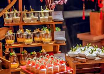 Assortment baked pastry in the buffet. Various different types of sweet cakes, cookies, candies, fruits and other desserts on display. Catering for birthday, wedding, Sunday brunch or other event