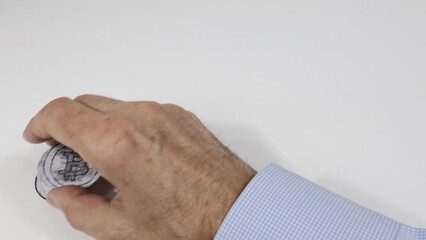 Bitcoin virtual currency, rest over a white background by man's hand.