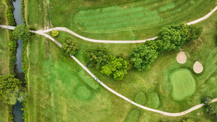 Golf course aerial above two golf carts near lush green holes with trees, Crestview Golf Club
