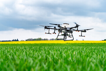 Drone quadcopter flying over a field of yellow flowers