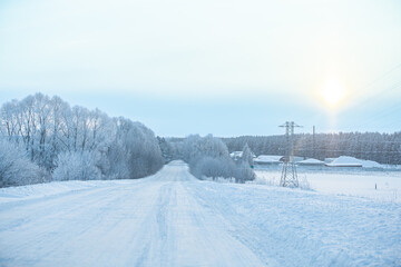 Fototapeta na wymiar Winter highway past rural landscapes. Ice Road