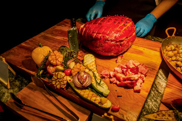 Carving station with meat variety among catering banquet table. Variety of snacks, appetizers, seafood and cooked meals displayed as buffet for wedding, Christmas, business corporate, birthday party