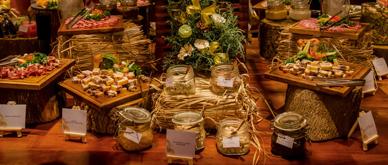 Catering banquet table with different food. Variety of snacks, appetizers, seafood and cooked meals...