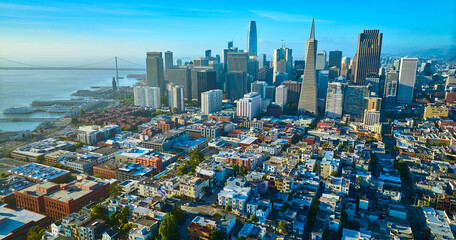 San Francisco golden light on city from aerial above buildings with skyscrapers looming behind, CA - obrazy, fototapety, plakaty