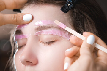 Hair removal, beauty and health concept. A young girl is getting an epilation procedure. A...