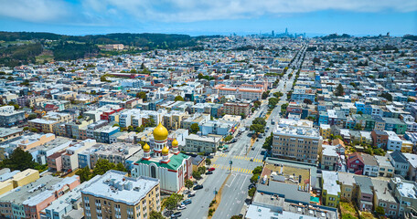 Outskirts of San Francisco, CA aerial street splitting apartment buildings with church and hotels